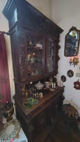 (LR) ANTIQUE CARVED OAK BUFFET WITH GLAZED DOORS OVER A GALLERY VIGNETTE, CARVED DOORS CIRCA