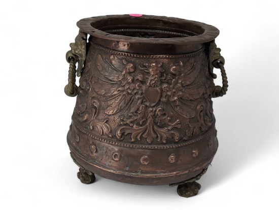 (LR) ANTIQUE HEAVILY DETAILED COPPER CAULDRON PLANTER POT SITTING IN THREE BRASS CLAW STYLE FEET.