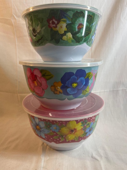 Three nesting plastic bowls with lids. Floral print. 9" tall....