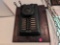 (BR2) VINTAGE WESTERN ELECTRIC TELEPHONE ON WOOD PLAQUE (MISSING THE PHONE). MEASURES 11-1/2