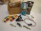 Box of fishing gear including fish, attractant, plastic and worm dye, spinning reel, and lures.
