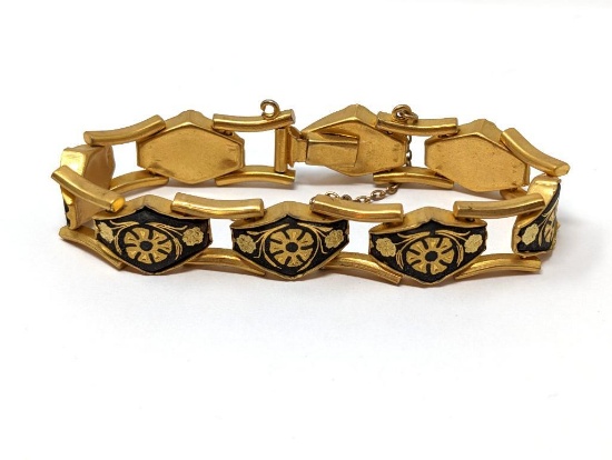 DAMASCENE LINK BRACELET. GOLD TONE WITH BLACK ENAMEL EMBELLISHMENTS. SAFETY CHAIN NEEDS TO BE