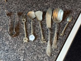 Seven Decorative Silver-Colored Utensils with Ornate Handles