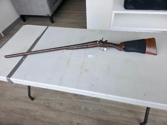 unmarked Double Barrel Shotgun with wooden stock and has ammo, in good condition.