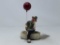 CLOWN SITTIING ON A STONE WITH A BALLOON