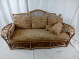 Bent cane sofa with horse pattern cushions.