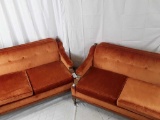 Pair of mid century modern orange loveseats.