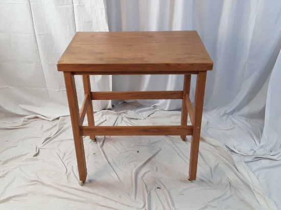 WOODEN TABLE ON CASTERS.