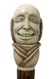 Bone or Tusk Engraved and Carved Exaggerated Expression Gentleman Cane on Wooden Shaft