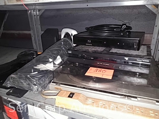 Lot on shelf of record player, Blu-Ray player, cable box, Blue Tooth speakers, power cords, fan
