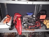 Lot on shelf of work lights, electric drill, electric hedge trimmer, electric cutout tool
