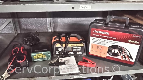 Lot on Shelf of Husky Booster Cables, Ampeak Smart Charger, Deltran Battery Tender Trickle Charger,