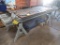 LOT: (1) 28 in. x 112 in. T-Slot Machine Table on (2) Steel Horses, with 6 in. Machine Vise