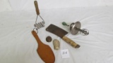 Vintage kitchen items: green handled mixer, cleaver, potato masher, wood paddle, stork & lobster mol