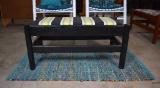 Black Wooden Bench with Upholstered Padded Seat & Blue Rag Woven Rug
