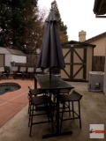 Patio bar table and stool chairs, with umbrella, table has shelves on one end