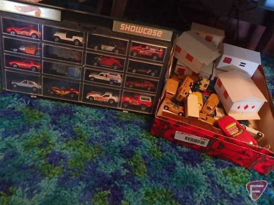 Metal and plastic toy cars, some Hot Wheels, plastic garages, and plastic showcase, all