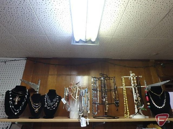 Assortment of necklaces with display stands. All on top shelf