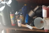 Contents of shelf: oil, grease guns, funnels, flex seal tire repai