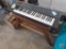 Casio CT-390 electric keyboard, wood bench, and sheet music.