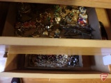 Contents of two drawers: women's brooches, bracelets, and hat pins, eyeglasses,