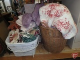 Comforter, bedspread, towels, afghan, table linens. All items in both wicker baskets