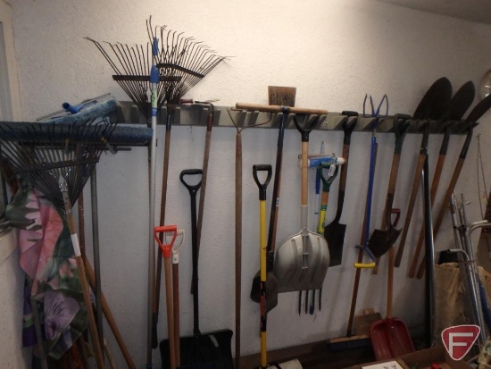 Lawn and garden tools, shovels, rakes, brooms, and decorative flags. All tools and flags on wall.
