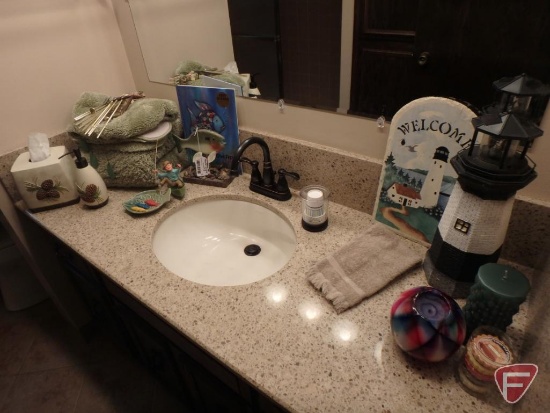 Bathroom rugs, tissue cover, soap dispenser, wind chimes, fish themed decorations.