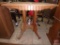 Wood ornate occasional table on wheels, one leg needs repair, 30inHx28inx22in