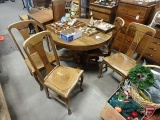 Vintage wood 45in round pedestal table on wheels, (4) 10-in leaves, (4) matching chairs.