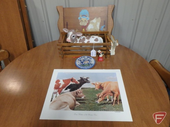 Cow items, print, napkin holder, ceramic figurines, cow bell, and wall decoration. All cow items on