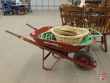 Metal wheelbarrow with flat tire, garden hose, wicker basket and (2) wicker hats.