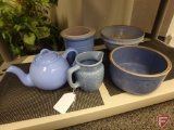Blue pottery pieces, pitcher, teapot, bowls, all on bottom shelf