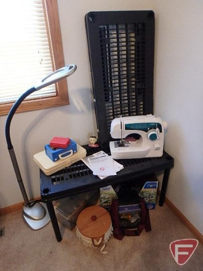 Brother XL 2600i sewing machine and notions on black shelving