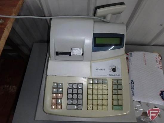Sharp XE-A403 electric cash register, roles of paper tape, and briefcase.