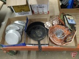 Canteen, mess kits, cast iron skillet, metal baking forms, and trivets. Contents of 3 boxes.