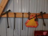 Primitive tools and slow moving triangle and truck tire wrenches, 8 pieces hanging on wall