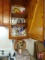 Contents of cupboard and counter below: wall clock, decorative box, metal wine rack,