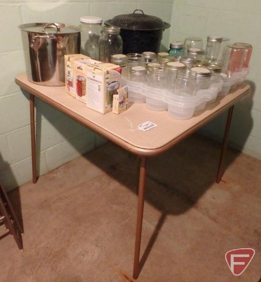 Canning supplies: enamel cooker, jars, pot with lid, trays, and folding table