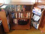 Assortment of VHS movies, in cabinet on rollers, VHS rewinder.