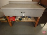 Workbench and contents: tape dispensers, shrink wrap, and packaging tape