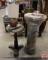 Fiskars pinking shears, piano stool, lamp, and ceramic column plant stand