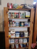 Contents of shelf: paints, calking, spray paint, tape, glue, and other painting supplies
