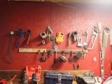Tools hanging on wall; saws, levels, clamps, oil filter wrenches, stapler
