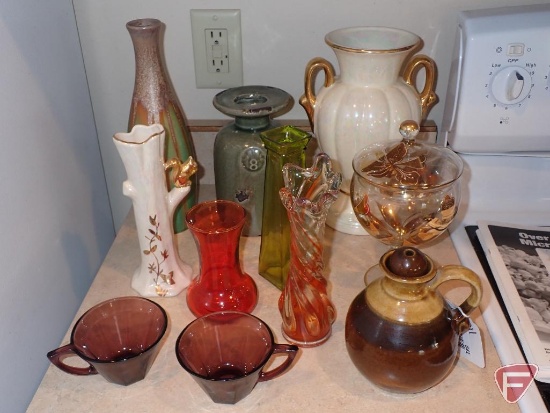 Vases, bowls and cookbooks, all in cupboards and counter by stove