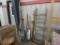 Shovels, yard and garden tools, wind chime, wood ladder. All items against wall.
