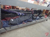Assortment of downhill snow skis, poles and boots, carry bags. All items on bottom shelf of cart.