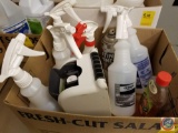 Box containing a soap dispenser and other partially used cleaning spray bottles