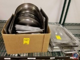 box containing a variety of steam table lids and plastic Cambros lids