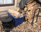 Black metal ash can w/ lid and shovel, tote full of split firewood, rolling firewood caddy/rack full